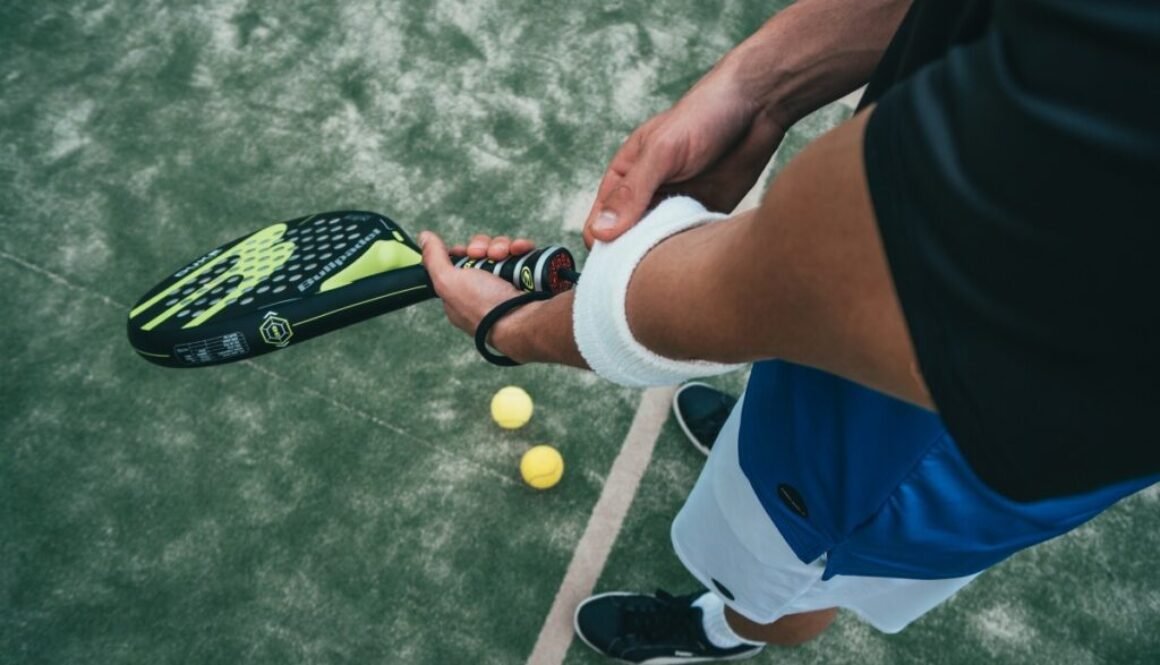 person-holding-black-and-green-tennis-racket-1103829_1